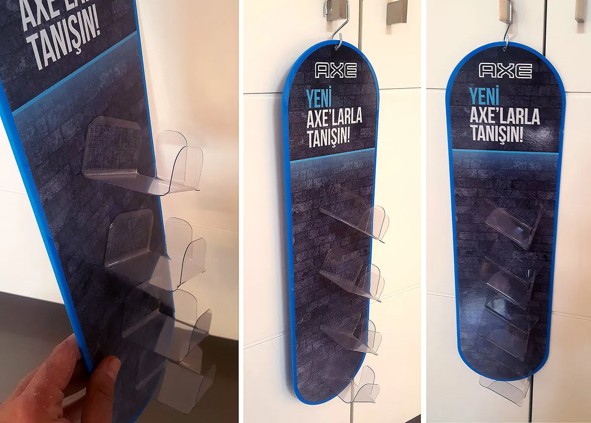 Axe Asalak Deodorant Standı; deodorant ürünlerini raf yanında dikey biçimde sergileyen askılı teşhir uygulaması.